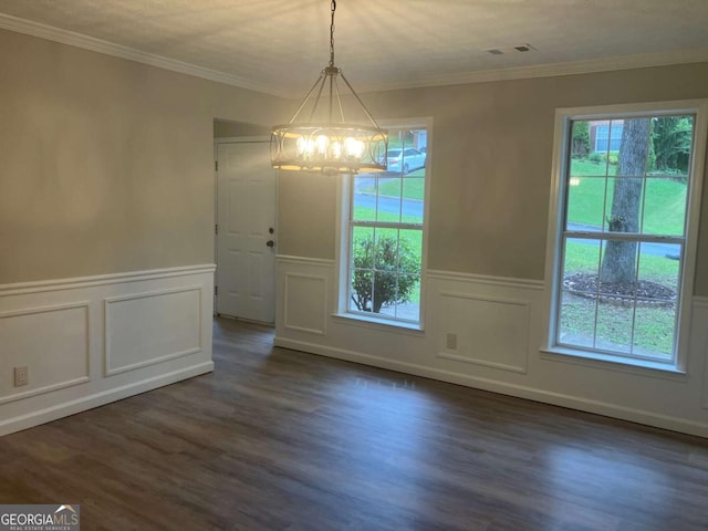 7593 Watson Bay Ct, Stone Mountain, GA 30087 - unfurnished dining area featuring a chandelier, a decorative wall, dark wood-type flooring, a wainscoted wall, and crown molding