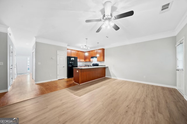 5057 Lower Elm St, Atlanta, GA 30349 - kitchen featuring black fridge, open floor plan, a peninsula, brown cabinets, and light wood finished floors