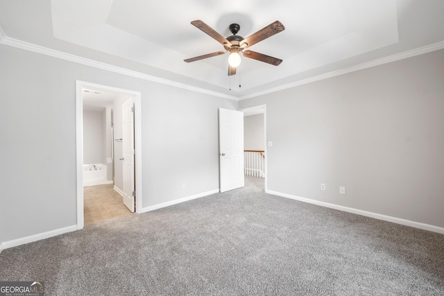 5057 Lower Elm St, Atlanta, GA 30349 - unfurnished bedroom featuring a tray ceiling, carpet flooring, ornamental molding, baseboards, and ensuite bathroom