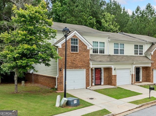 5057 Lower Elm St, Atlanta, GA 30349 - view of front facade with a front lawn, concrete driveway, a garage, and a shingled roof