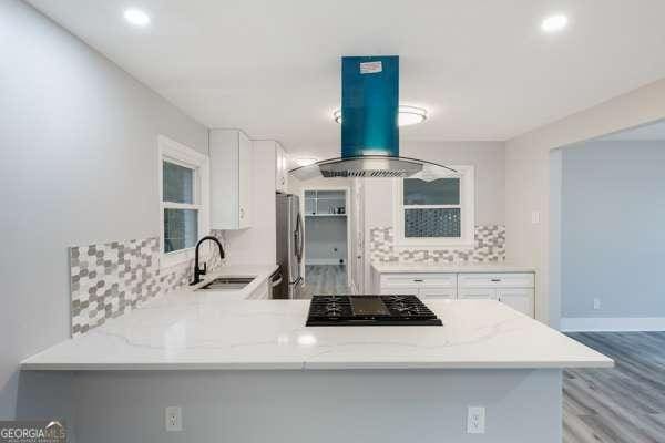 1506 Vine St NE, Gainesville, GA 30501 - kitchen featuring a sink, black gas cooktop, island range hood, decorative backsplash, and recessed lighting
