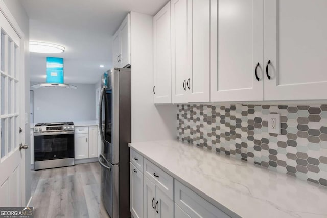 1506 Vine St NE, Gainesville, GA 30501 - kitchen with appliances with stainless steel finishes, island exhaust hood, white cabinetry, backsplash, and light stone counters