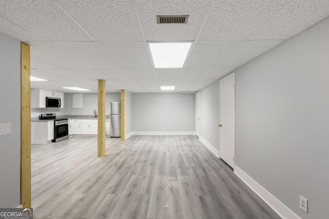 1506 Vine St NE, Gainesville, GA 30501 - finished basement with freestanding refrigerator, a paneled ceiling, light wood-style flooring, a sink, and baseboards