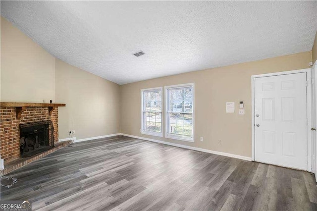 5422 Timor Trl, Lithonia, GA 30038 - unfurnished living room featuring a textured ceiling, wood finished floors, a brick fireplace, and baseboards