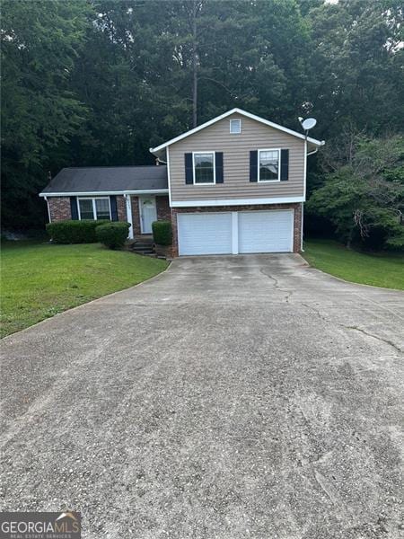 5388 Robertson Path, Lithonia, GA 30038 - tri-level home with a garage, asphalt driveway, brick siding, and a front lawn