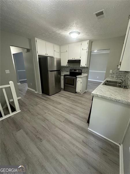 5388 Robertson Path, Lithonia, GA 30038 - kitchen featuring stainless steel appliances, a sink, backsplash, light countertops, and a textured ceiling