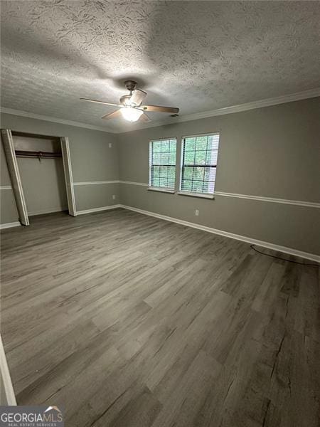 5388 Robertson Path, Lithonia, GA 30038 - unfurnished bedroom featuring wood finished floors, ornamental molding, baseboards, a textured ceiling, and a closet
