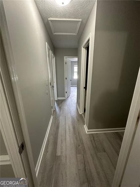5388 Robertson Path, Lithonia, GA 30038 - hallway featuring attic access, wood finished floors, baseboards, and a textured ceiling