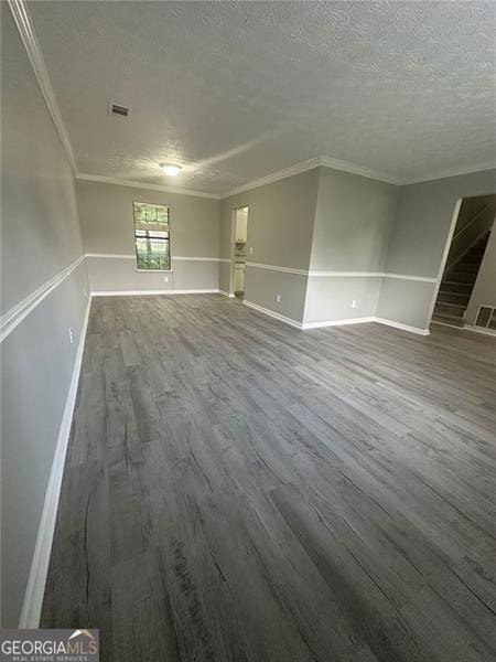 5388 Robertson Path, Lithonia, GA 30038 - unfurnished living room with dark wood finished floors, a textured ceiling, crown molding, and baseboards