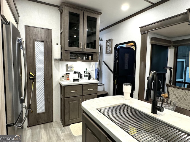 279 Leisure Acres Dr, Cleveland, GA 30528 - kitchen with freestanding refrigerator, a sink, light wood finished floors, crown molding, and dark brown cabinets