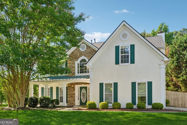 1093 Forest View Ln SW, Lilburn, GA 30047 - view of front of house with a chimney, a standing seam roof, stucco siding, metal roof, and a porch