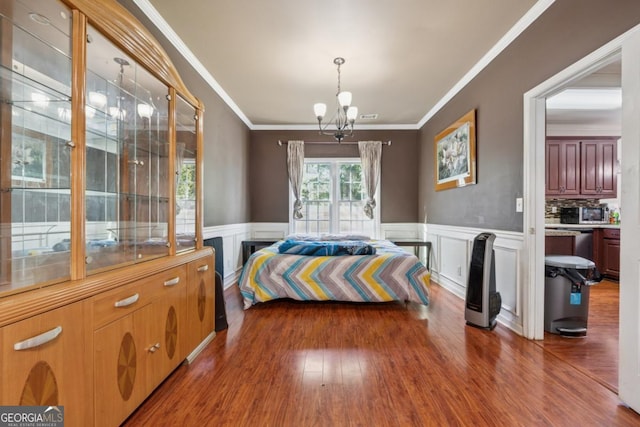 1093 Forest View Ln SW, Lilburn, GA 30047 - bedroom featuring a chandelier, ornamental molding, wood finished floors, wainscoting, and a decorative wall