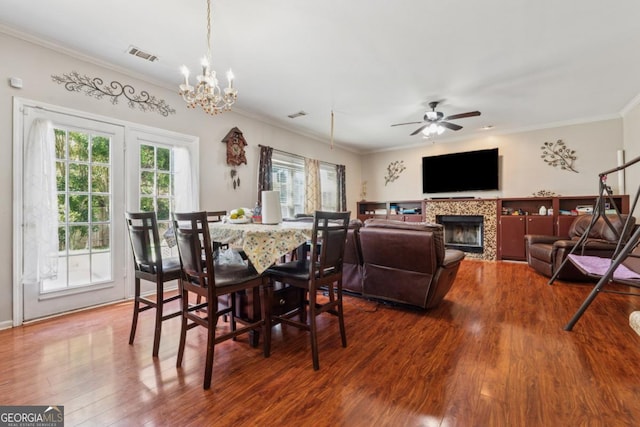 1093 Forest View Ln SW, Lilburn, GA 30047 - dining area with wood finished floors, ornamental molding, a chandelier, ceiling fan, and a tiled fireplace