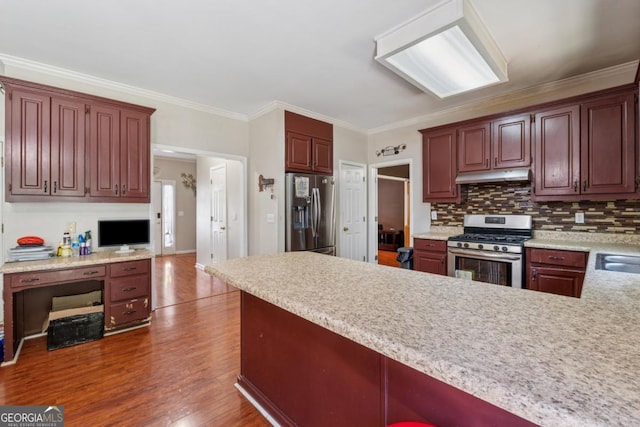 1093 Forest View Ln SW, Lilburn, GA 30047 - kitchen featuring appliances with stainless steel finishes, under cabinet range hood, light countertops, wood finished floors, and a peninsula