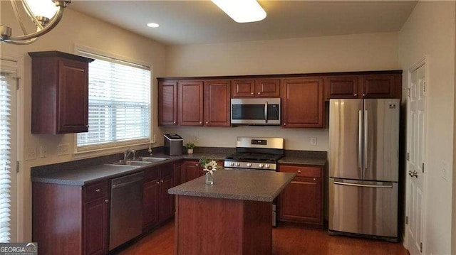 1379 Thornborough Dr, Alpharetta, GA 30004 - kitchen featuring stainless steel appliances, a sink, dark countertops, a center island, and wood finished floors