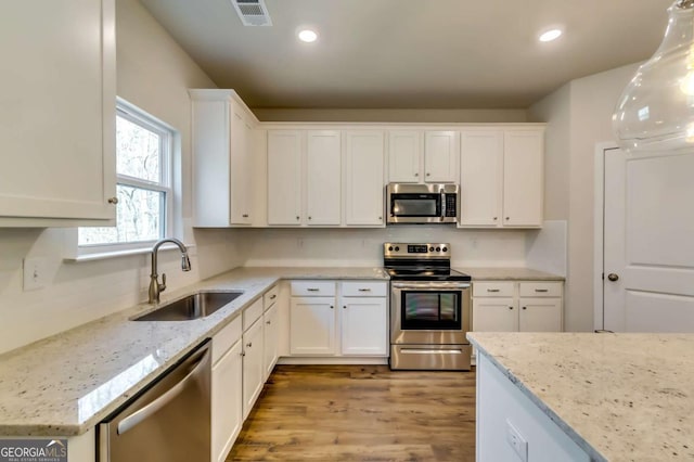 407 Shoals Trl, Dallas, GA 30132 - kitchen with stainless steel appliances, a sink, white cabinets, light wood-type flooring, and recessed lighting