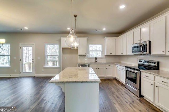 407 Shoals Trl, Dallas, GA 30132 - kitchen with stainless steel appliances, a kitchen island, dark wood finished floors, recessed lighting, and white cabinetry