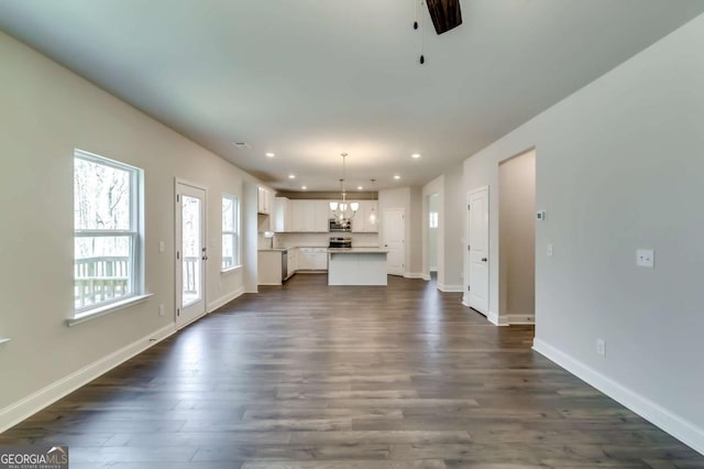 407 Shoals Trl, Dallas, GA 30132 - unfurnished living room with recessed lighting, dark wood finished floors, baseboards, and a chandelier