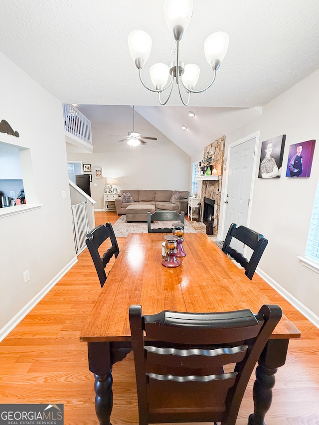 521 Lake Jordan Blvd W, Kingsland, GA 31548 - dining room featuring ceiling fan, lofted ceiling, light wood-style flooring, a stone fireplace, and a chandelier