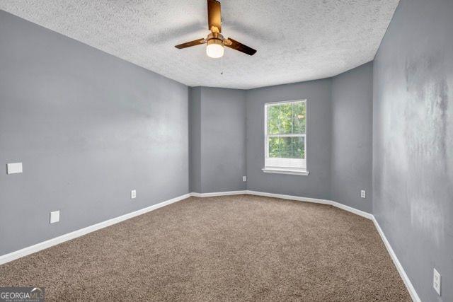 2505 Tiffany Ct, Conyers, GA 30013 - empty room with a textured ceiling, ceiling fan, carpet, and baseboards