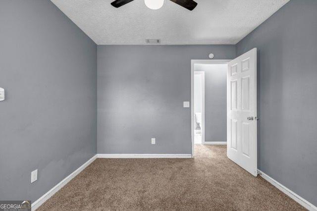 2505 Tiffany Ct, Conyers, GA 30013 - carpeted spare room with a textured ceiling, ceiling fan, and baseboards