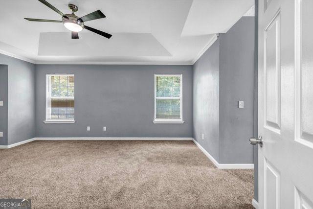 2505 Tiffany Ct, Conyers, GA 30013 - carpeted empty room with a raised ceiling, healthy amount of natural light, ornamental molding, and baseboards