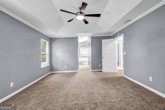 2505 Tiffany Ct, Conyers, GA 30013 - carpeted empty room with a tray ceiling, a ceiling fan, ornamental molding, and baseboards
