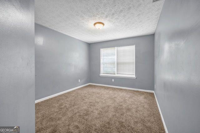 2505 Tiffany Ct, Conyers, GA 30013 - spare room with carpet flooring, baseboards, and a textured ceiling