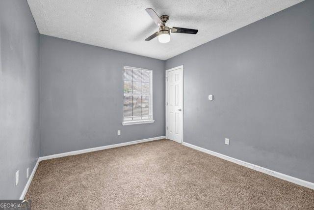 2505 Tiffany Ct, Conyers, GA 30013 - carpeted empty room with a ceiling fan, a textured ceiling, and baseboards