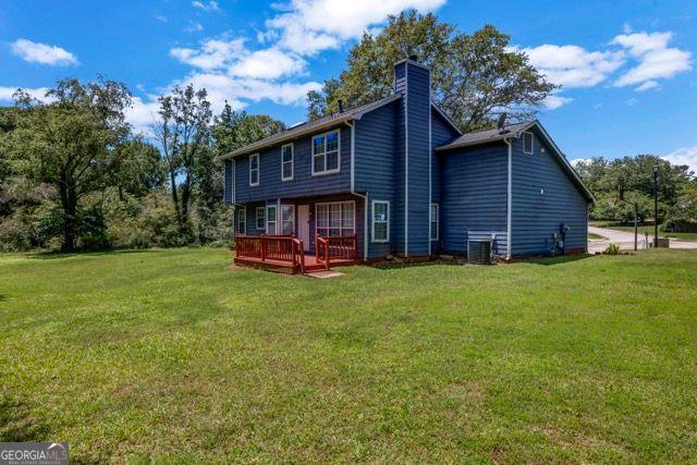 2505 Tiffany Ct, Conyers, GA 30013 - rear view of property with a lawn, a wooden deck, a chimney, and central air condition unit