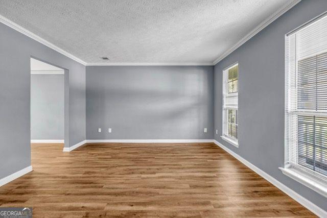 2505 Tiffany Ct, Conyers, GA 30013 - spare room featuring a textured ceiling, crown molding, wood finished floors, and baseboards