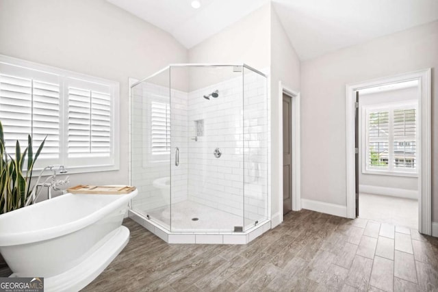 1596 Fearn Cir NE, Brookhaven, GA 30319 - full bath with a shower stall, a freestanding bath, wood finished floors, vaulted ceiling, and baseboards