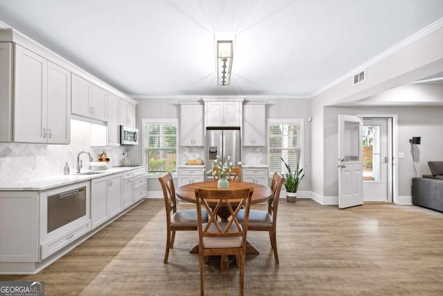 1596 Fearn Cir NE, Brookhaven, GA 30319 - dining area with healthy amount of natural light, light wood-style flooring, baseboards, and ornamental molding