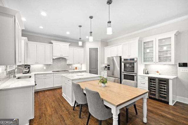 1596 Fearn Cir NE, Brookhaven, GA 30319 - kitchen featuring stainless steel appliances, a sink, beverage cooler, ornamental molding, and backsplash