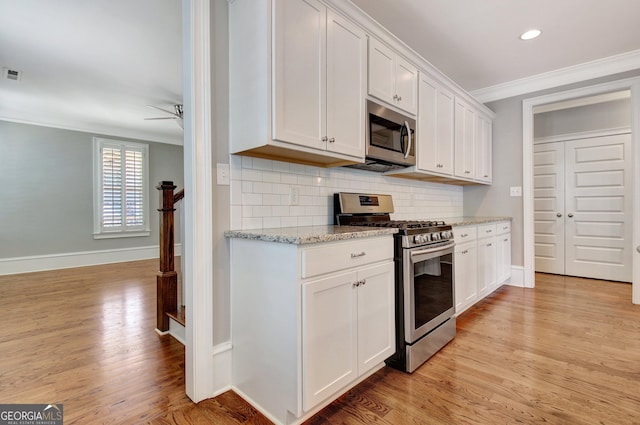 46 Horseshoe Bend Way, Senoia, GA 30276 - kitchen with stainless steel appliances, ornamental molding, a ceiling fan, light wood-style floors, and tasteful backsplash