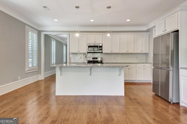 46 Horseshoe Bend Way, Senoia, GA 30276 - kitchen featuring stainless steel appliances, crown molding, white cabinetry, decorative backsplash, and hanging light fixtures