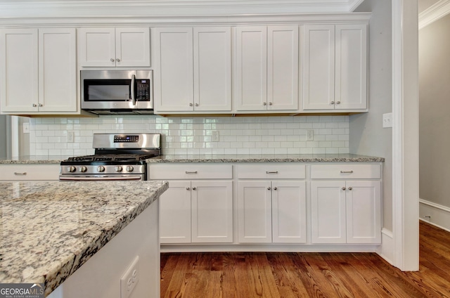 46 Horseshoe Bend Way, Senoia, GA 30276 - kitchen with stainless steel appliances, white cabinets, ornamental molding, dark wood-style flooring, and backsplash