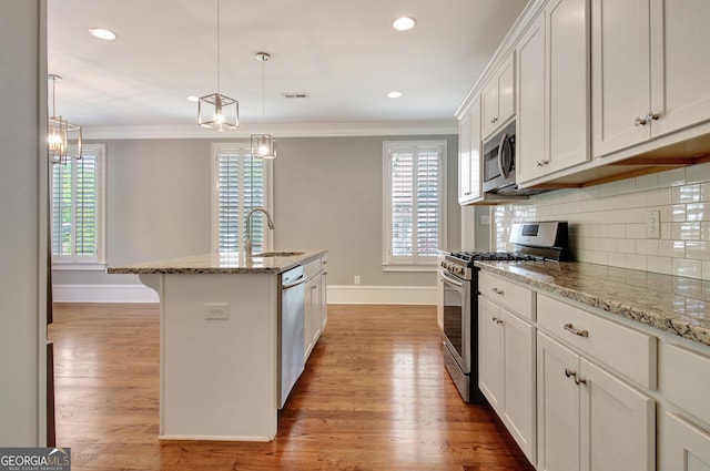 46 Horseshoe Bend Way, Senoia, GA 30276 - kitchen featuring appliances with stainless steel finishes, a sink, baseboards, crown molding, and light wood-style flooring