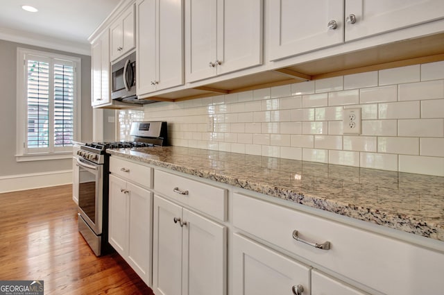 46 Horseshoe Bend Way, Senoia, GA 30276 - kitchen with appliances with stainless steel finishes, light wood finished floors, baseboards, crown molding, and white cabinetry
