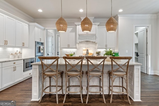15626 Birmingham Hwy, Alpharetta, GA 30004 - kitchen with stainless steel appliances, backsplash, a kitchen breakfast bar, an island with sink, and white cabinetry