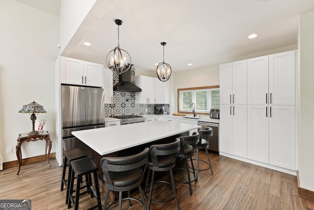457 Monroe Ridge Rd, Sautee Nacoochee, GA 30571 - kitchen with appliances with stainless steel finishes, wall chimney exhaust hood, a chandelier, decorative backsplash, and light countertops