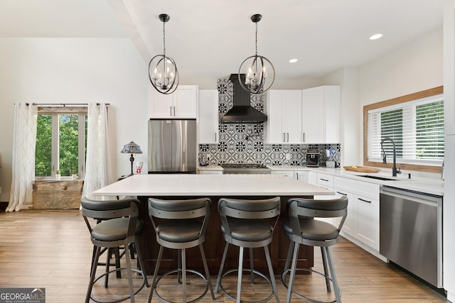 457 Monroe Ridge Rd, Sautee Nacoochee, GA 30571 - kitchen with stainless steel appliances, wall chimney range hood, light countertops, a chandelier, and decorative backsplash