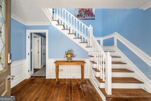 4259 Kings Troop Rd, Stone Mountain, GA 30083 - stairs featuring wood finished floors, a decorative wall, wainscoting, a textured ceiling, and crown molding
