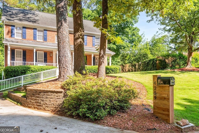 4259 Kings Troop Rd, Stone Mountain, GA 30083 - georgian-style home featuring brick siding, covered porch, and a front yard