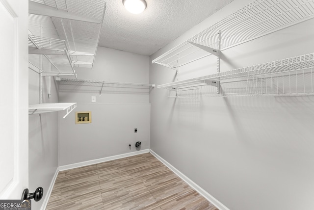 40 Wenham Ln, Sharpsburg, GA 30277 - laundry room with washer hookup, hookup for an electric dryer, baseboards, gas dryer hookup, and wood finished floors