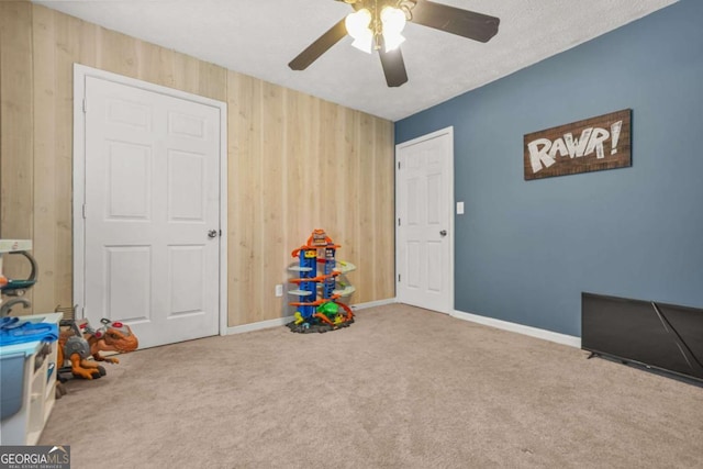2959 Pritchards Mill Trl, Douglasville, GA 30135 - playroom featuring wood walls, a ceiling fan, carpet flooring, and baseboards