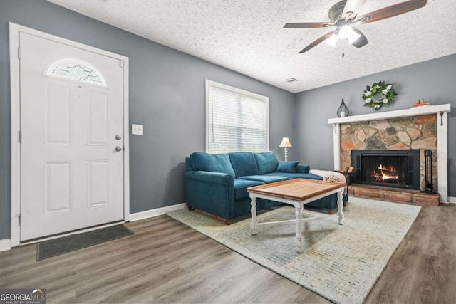 2959 Pritchards Mill Trl, Douglasville, GA 30135 - living area with plenty of natural light, ceiling fan, wood finished floors, a stone fireplace, and a textured ceiling