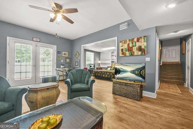2959 Pritchards Mill Trl, Douglasville, GA 30135 - living room with baseboards, a ceiling fan, light wood-type flooring, stairway, and french doors