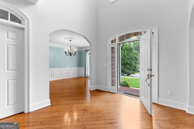 160 Torrey Pines Ct, Newnan, GA 30265 - foyer entrance with a chandelier, arched walkways, light wood-style floors, and a towering ceiling