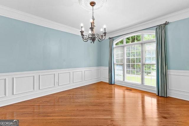 160 Torrey Pines Ct, Newnan, GA 30265 - empty room with a chandelier, crown molding, a wainscoted wall, wood finished floors, and a decorative wall